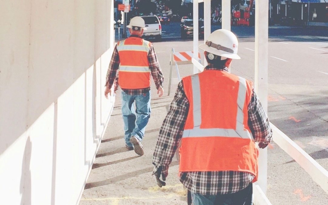 two construction workers surveying a project