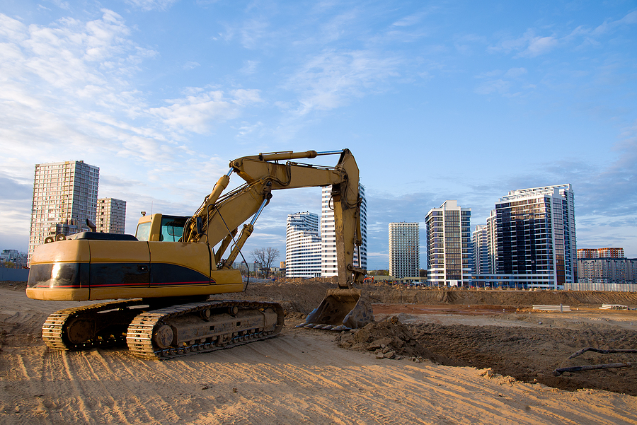 Excavator Working At Construction Site. Backhoe Digs Ground For